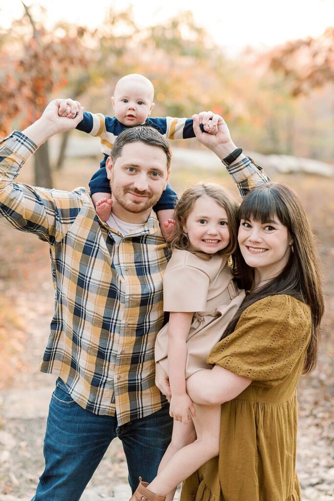 Family of four with baby on father's shoulders during fall family session in Northern NJ